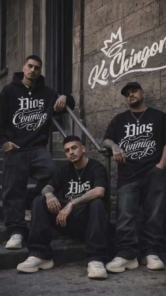 Three men wearing oversized black Dios Conmigo t-shirts standing and sitting on urban steps with Ke Chingon logo on wall streetwear video by Ke Chingon